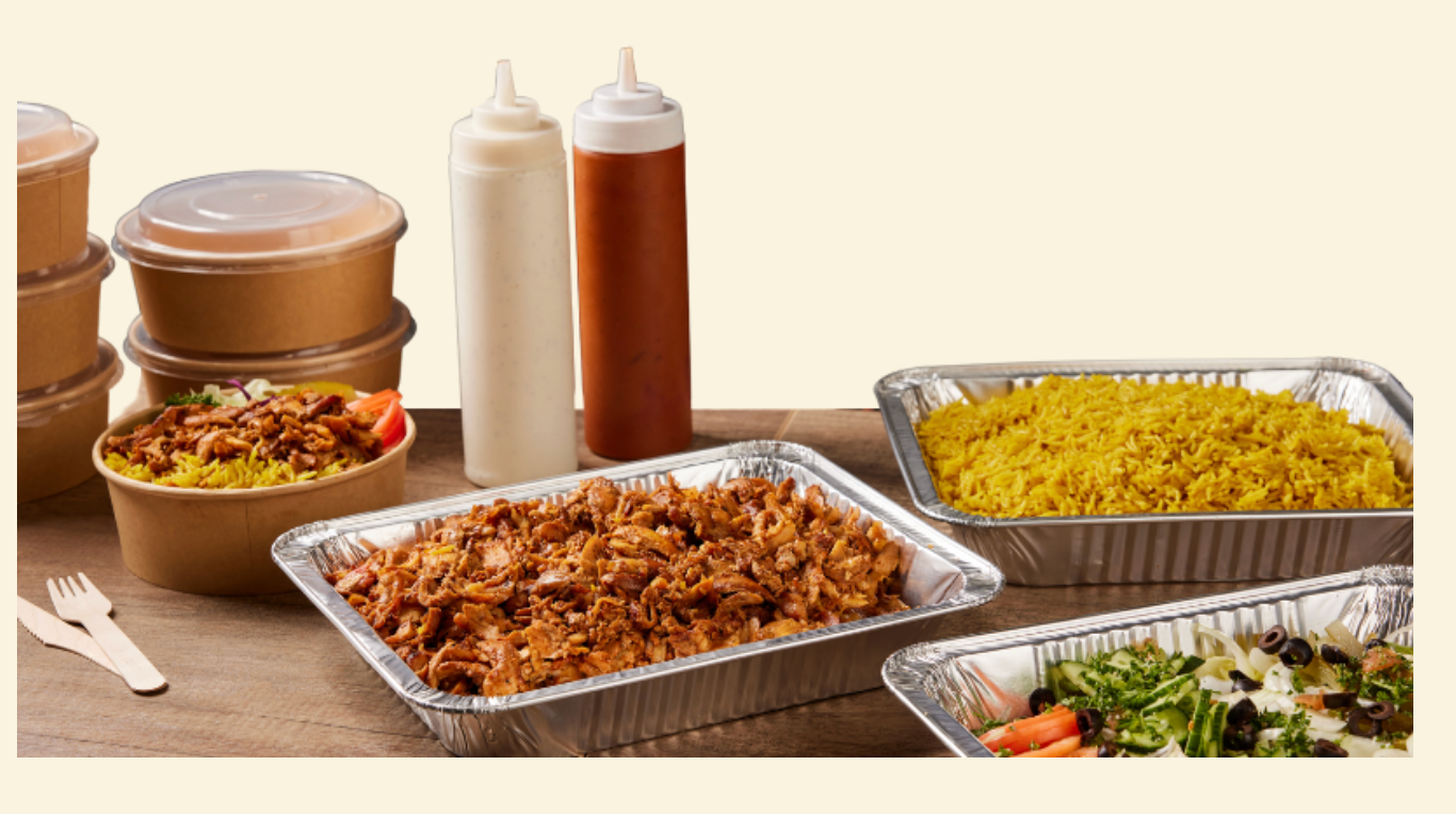 Shawarma West office catering spread with shawarma, rice, salad and sauces